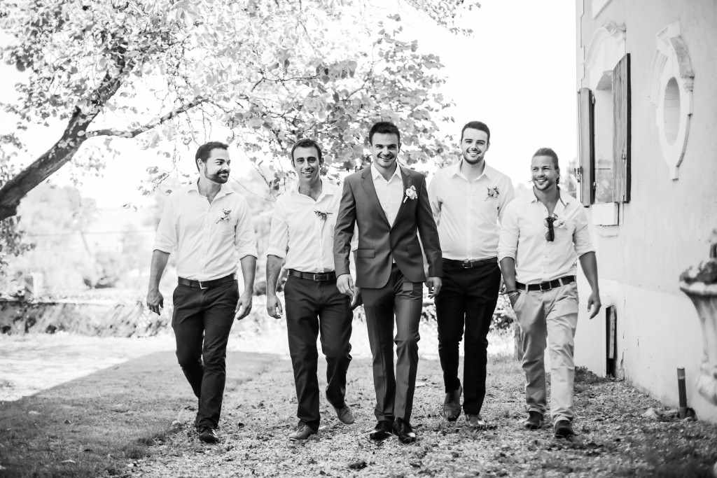 Men walking towards the camera during a wedding in France.
