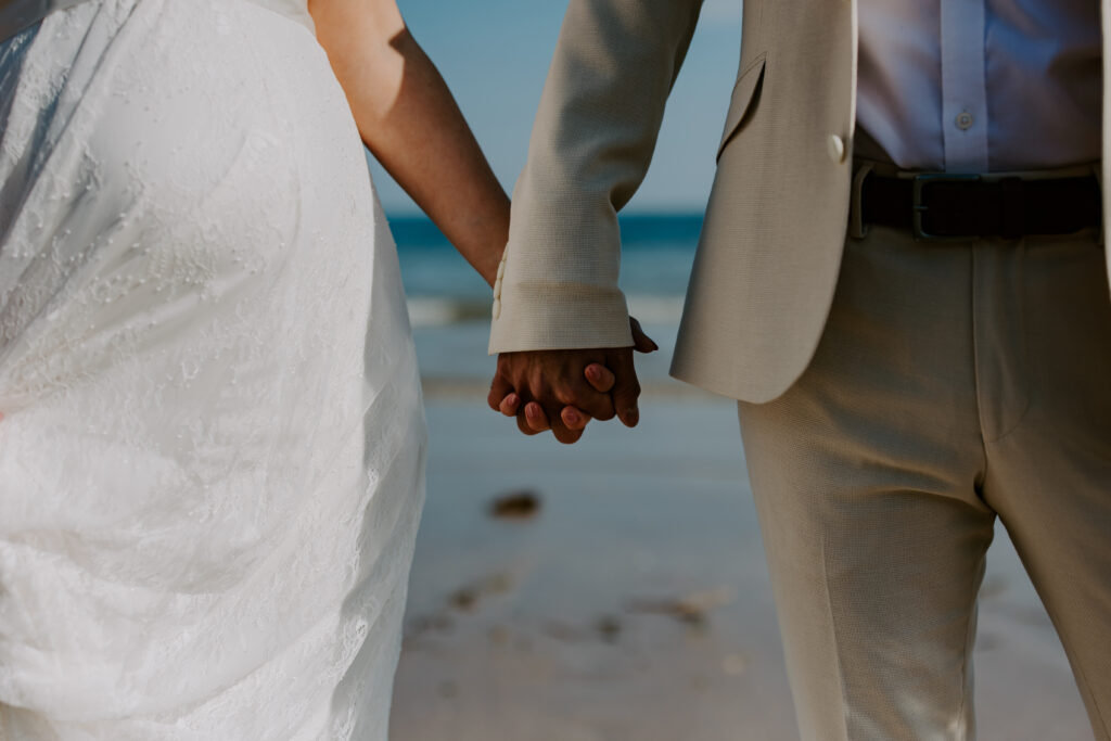 holding hands on the beach at Cornwall elopement wedding