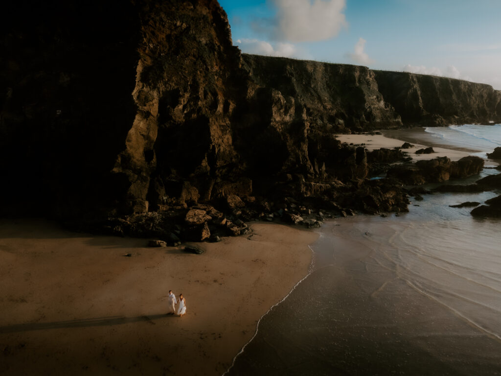 Drone image of a couple on a beach after wedding wearing wedding cloths